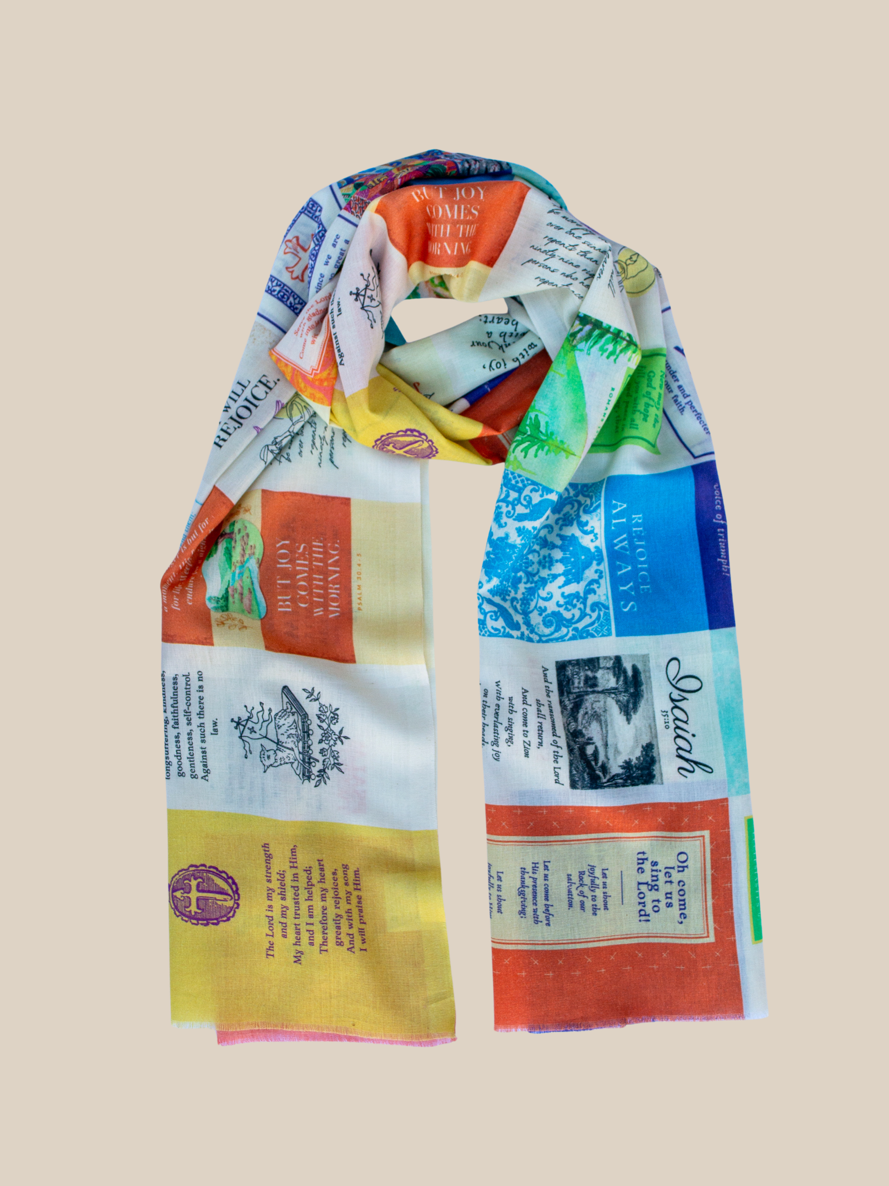 Joy Cotton prayer scarf by Prayer Scarves® shown laid flat and loosely knotted, featuring a multicolor patchwork design with scripture text blocks, decorative motifs, and varied patterned panels across the fabric.