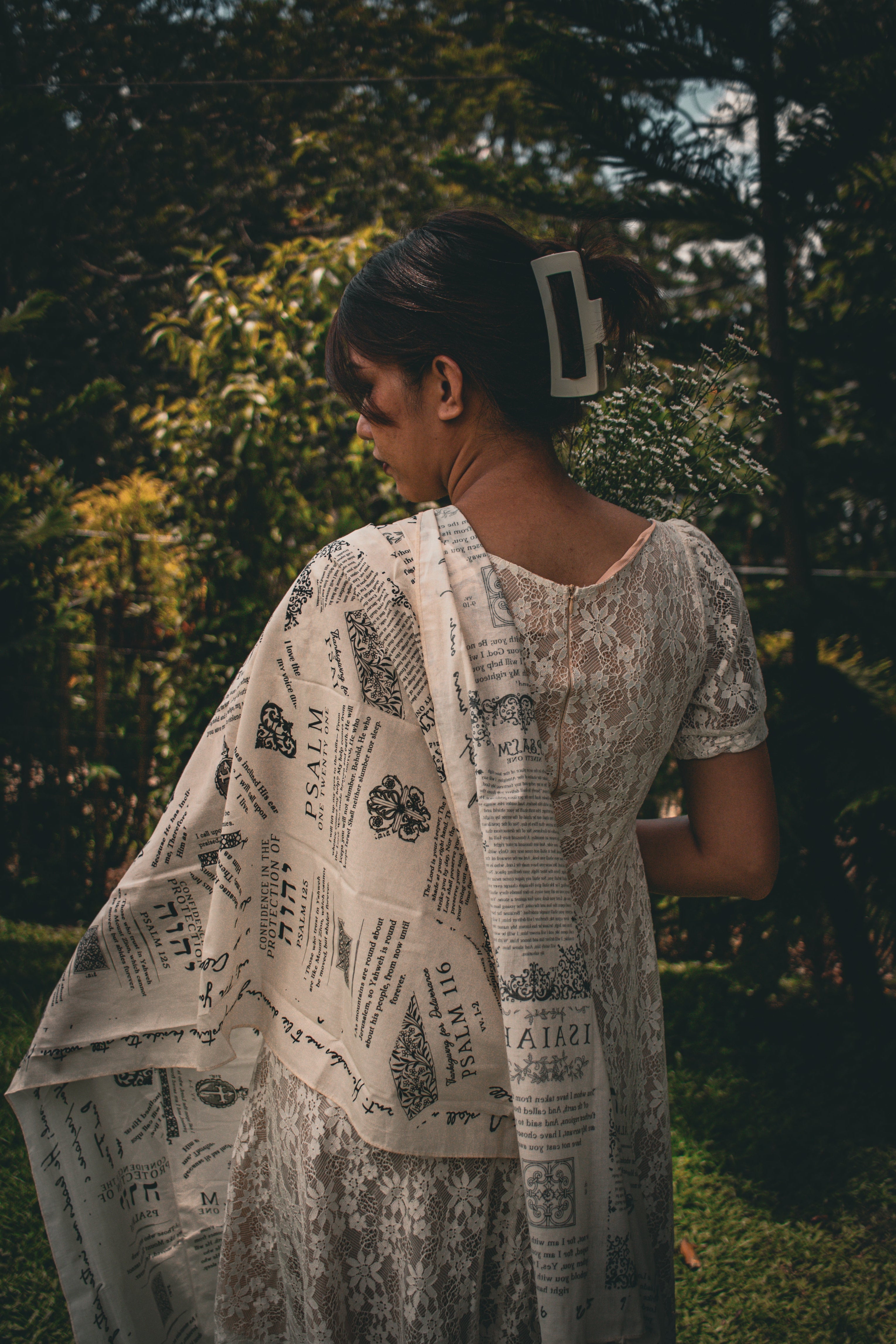 Cotton protection prayer scarf by Prayer Scarves® in ivory, worn draped over the shoulders outdoors, made from organic cotton and featuring Scripture passages about God’s protection