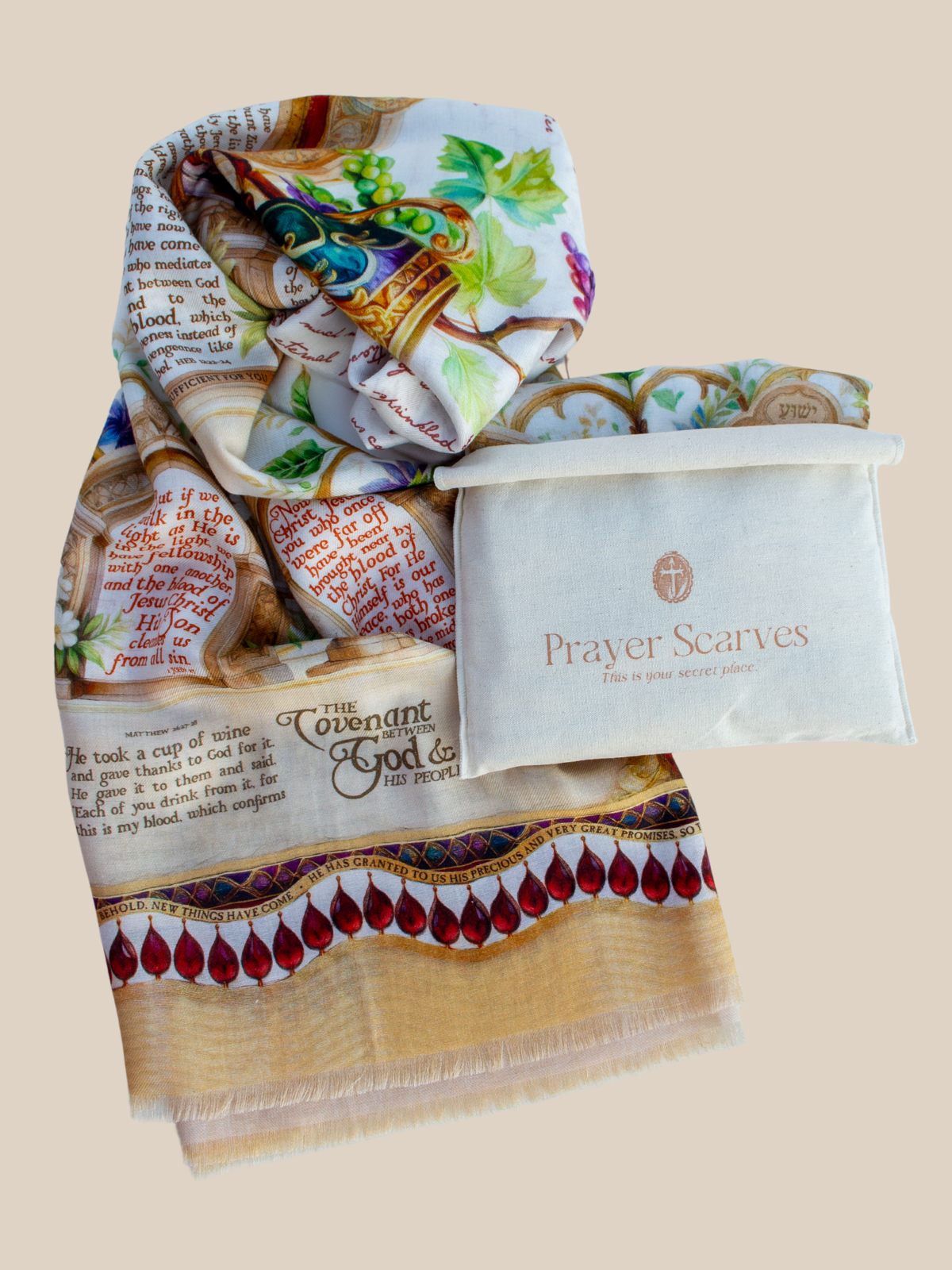 Covenant prayer scarf by Prayer Scarves® shown folded with a fabric storage pouch, featuring an illustrated chalice with grapes and vines, ornate architectural borders, floral details, and scripture text visible across the scarf.