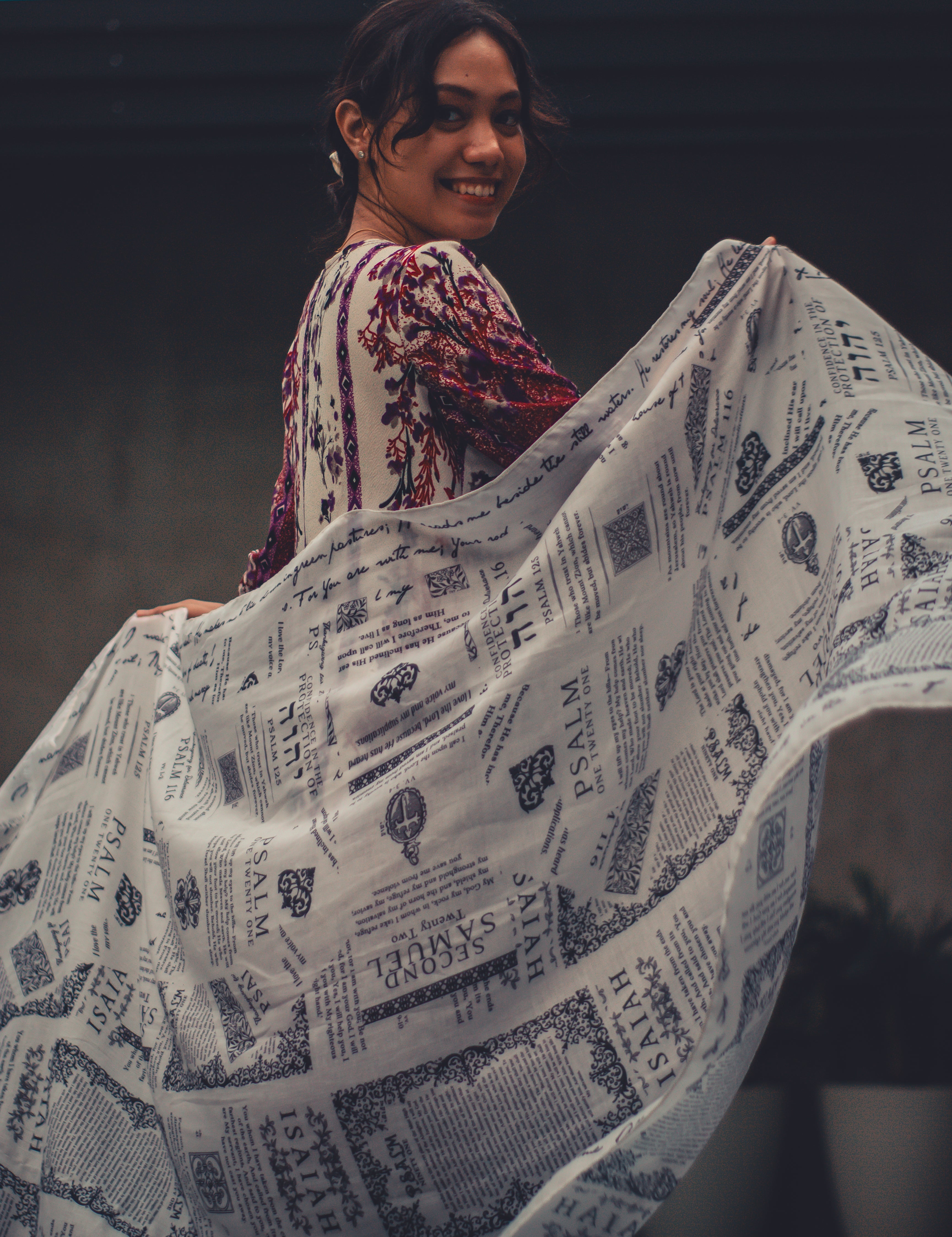 Protection prayer scarf by Prayer Scarves® in ivory, worn open and held out to display Scripture passages about God’s protection, shown as a gentle, lifestyle-style moment of prayer and trust in God