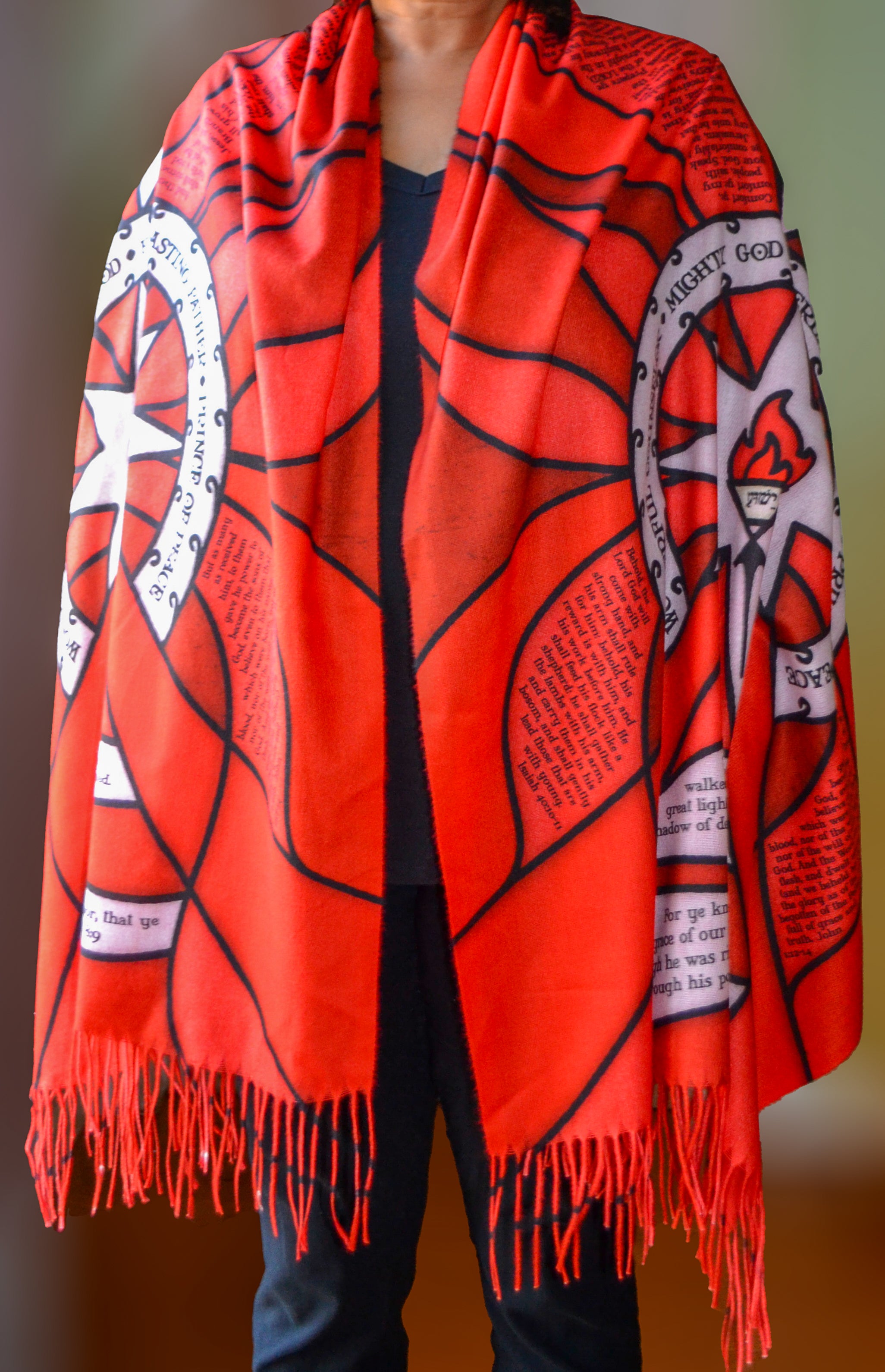Model wearing the Advent Prayer Scarf™ in red tones, featuring a stained-glass–inspired design with scripture text woven throughout.